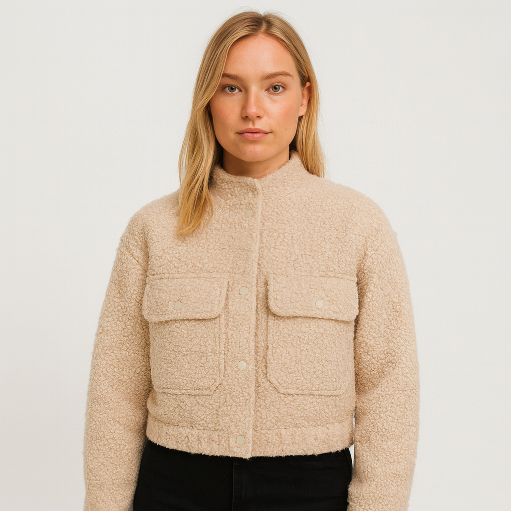Beige bouclé cropped jacket with stand collar, snap button closure, long sleeves, and front flap pockets, displayed on a white background.