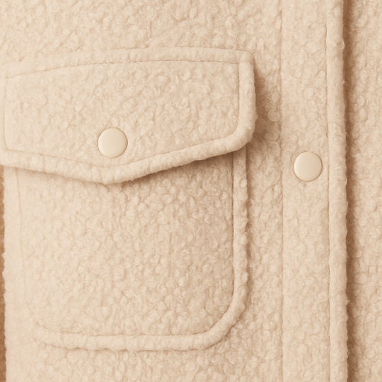 Beige bouclé cropped jacket with stand collar, snap button closure, long sleeves, and front flap pockets, displayed on a white background.