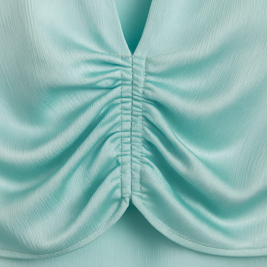 Aqua satin ruched blouse with plunging neckline and long sleeves.