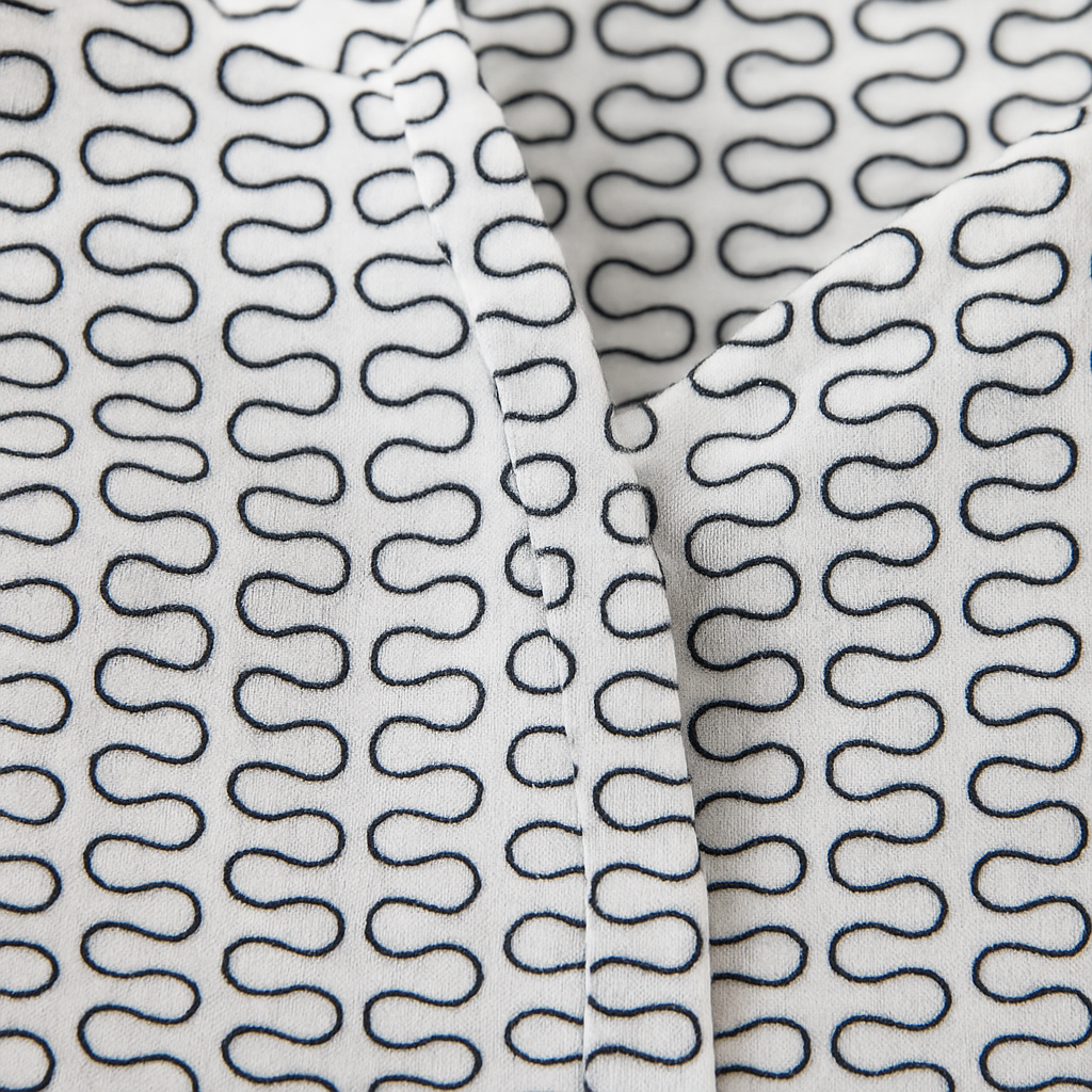 White button-down blouse with black geometric wave print and long sleeves.